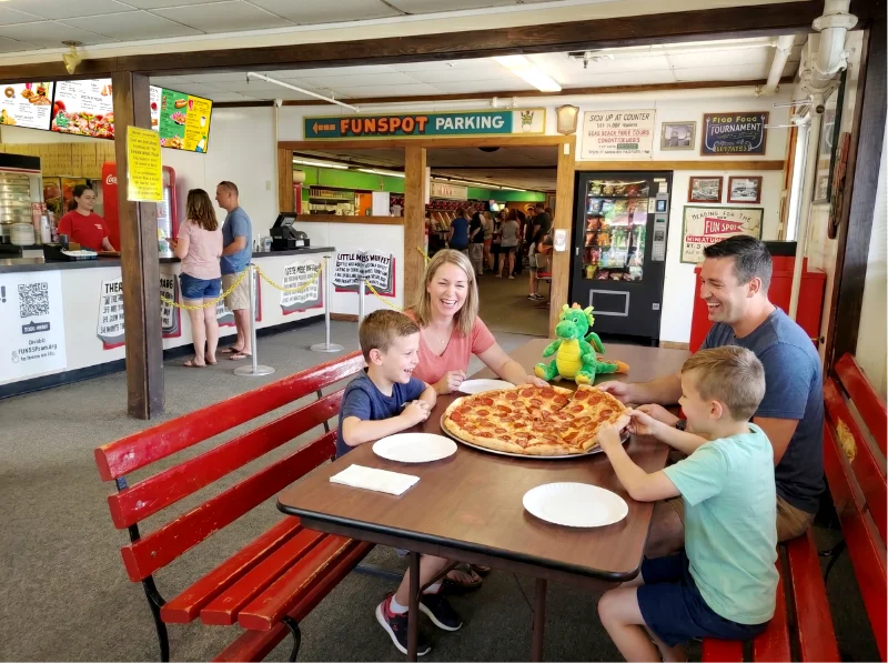 family eating pizza at Funspot's Braggin Dragon restaurant